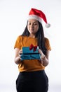 Portrait of Latina woman with Christmas hat looking sideways at gifts. Royalty Free Stock Photo