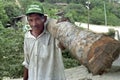 Portrait of Latino senior with firewood on shoulder