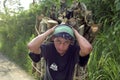 Portrait of Latino teen carrying firewood on head