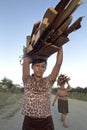 Portrait Latino woman carrying firewood on head