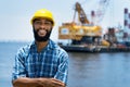 Portrait of laughing africa american offshore worker with digger and ocean