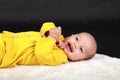 Portrait of laughing baby boy lying on back on white fur Royalty Free Stock Photo