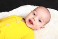 Portrait of laughing baby boy lying on white fur Royalty Free Stock Photo