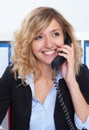 Portrait of laughing blond businesswoman at office at phone Royalty Free Stock Photo