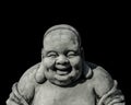 Portrait of a laughing buddha statue, islated on black background. Sign for peace and wisdom