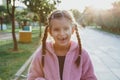 portrait of a laughing funny cheerful girl 6 years old in the park at sunset, missing front tooth,