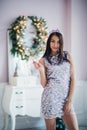 Portrait of a laughing girl wearing crown and holding magic wand while looking at camera in christmas decorations Royalty Free Stock Photo