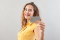 Portrait of laughing girlish woman with long hair do wear yellow top. Hand showing credit card isolated on white background Royalty Free Stock Photo