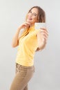 Portrait of laughing girlish woman with long hair do wear yellow top. Hand showing credit card isolated on white background Royalty Free Stock Photo