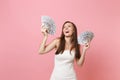 Portrait of laughing happy bride woman in white wedding dress holding bundle lots of dollars, cash money on