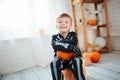 Portrait of laughing little boy in a skeleton costume is ready to celebrate Halloween. Boy in a halloween dress-up room.