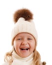 Portrait of a laughing little girl in a knitted hat with a pompon, scarf and sweater. Isolated on white background Royalty Free Stock Photo