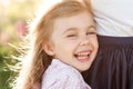 Portrait of a laughing little girl near mom at sunset