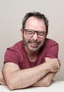 Portrait of a laughing mature man with beard wearing red t-shirt and glasses Royalty Free Stock Photo