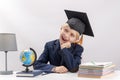 Portrait of laughing schoolboy in students hat and glasses next to globe. Studying and education concept