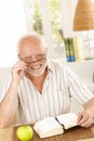 Portrait of laughing senior with book Royalty Free Stock Photo