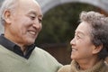 Portrait of laughing senior couple in front of round arch, Beijing