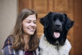 Portrait of laughing teenager girl sitting with her dog