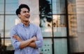 Portrait of Laughing Young Asian Businessman in the City. Crossed Arms and looking away. a Happy Man Royalty Free Stock Photo