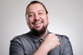 Portrait of laughing young man against grey wall. Happy guy smiling. Royalty Free Stock Photo