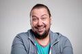 Portrait of laughing young man against grey wall. Happy guy smiling. Royalty Free Stock Photo