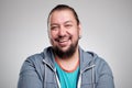 Portrait of laughing young man against grey wall. Happy guy smiling. Royalty Free Stock Photo