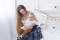 Portrait of laughing young mum together with a small son in a white room interior Royalty Free Stock Photo