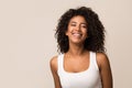 Portrait of laughing young woman against light background