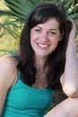 Portrait of laughing young woman relaxing on grass with palm tr Royalty Free Stock Photo