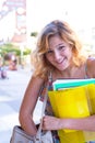 Portrait of a laughing young woman, student with colorful exercise books Royalty Free Stock Photo