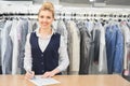 Portrait of a Laundry worker on the background of the clothing on hangers