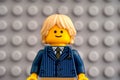 Portrait of Lego blond businessman minifigure against Lego gray baseplate