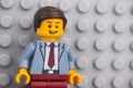 Portrait of a Lego businessman minifigure standing against lego gray baseplate