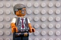 Portrait of Lego Commissioner James Gordon minifigure against gray baseplate background