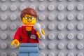 Portrait of Lego woman reporter minifigure with microphone against gray baseplate