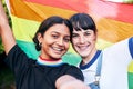 Portrait, lesbian and couple with flag for pride, freedom and happy or bonding at festival. Face, lesbian couple and