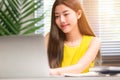 Portrait of lifestyle scene of young Asian woman feeling happy and confident working on laptop at her office desk in the natural Royalty Free Stock Photo