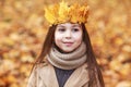 Portrait liitle cute girl with crown of leaves in autumn park