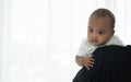 Portrait of little adorable African newborn baby smiling looking with bright eyes while parent carrying cute infant on shoulder Royalty Free Stock Photo