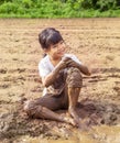 Portrait of a little adorable Asian girl sitting smiling and playing in the mud with fun. Family, healthy child, happiness concept Royalty Free Stock Photo