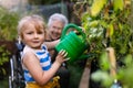 Portrait of a little adorable girl helping her grandmother in the garden.