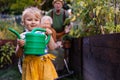 Portrait of a little adorable girl helping her grandparents in the garden.