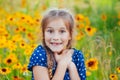 Portrait of a little adorable little girl smiling, in field with yellow flowers Royalty Free Stock Photo