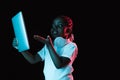 Portrait of little African-American girl isolated on dark background in neon Royalty Free Stock Photo