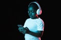 Portrait of little African-American girl isolated on dark background in neon Royalty Free Stock Photo