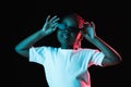 Portrait of little African-American girl isolated on dark background in neon Royalty Free Stock Photo