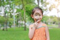 Portrait little Asian child girl looking through magnifying glass on park garden Royalty Free Stock Photo