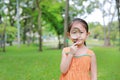 Portrait little Asian child girl looking through magnifying glass on park garden Royalty Free Stock Photo