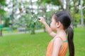 Portrait little Asian child girl looking through magnifying glass on park garden Royalty Free Stock Photo