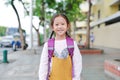 Portrait little Asian child girl with student shoulder schoolbag walking on walkway go to school. Back to school concept Royalty Free Stock Photo